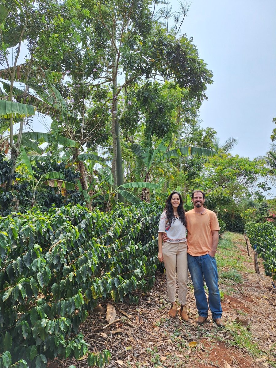 Cris e Pedro entre o cafezal e a agrofloresta do sítio